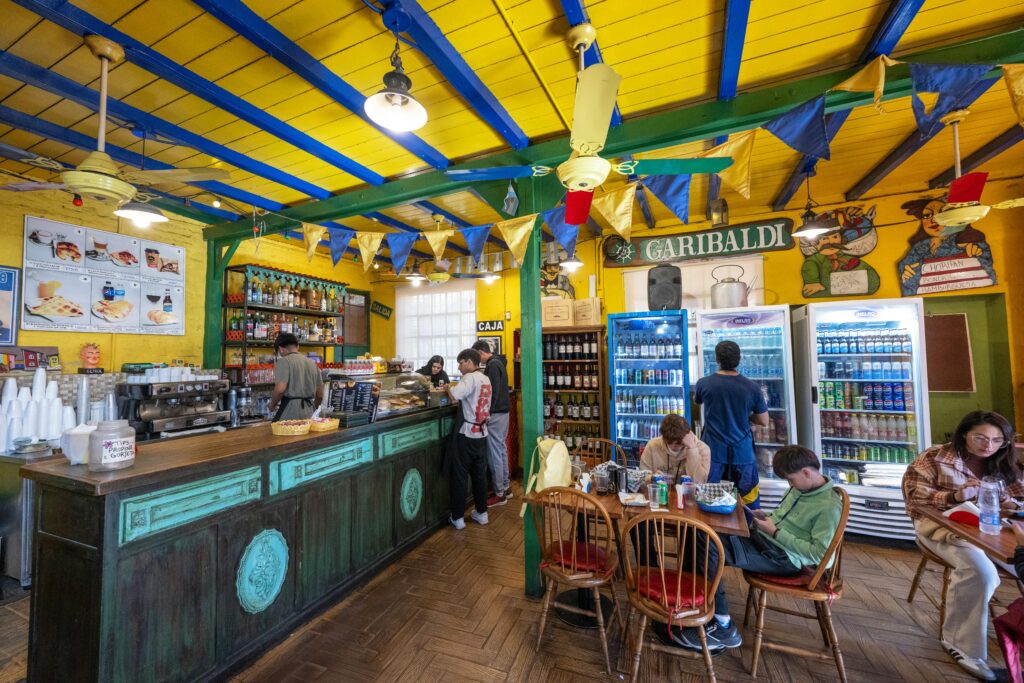Vibrant café scene in Buenos Aires with people enjoying leisure time and colorful decor.